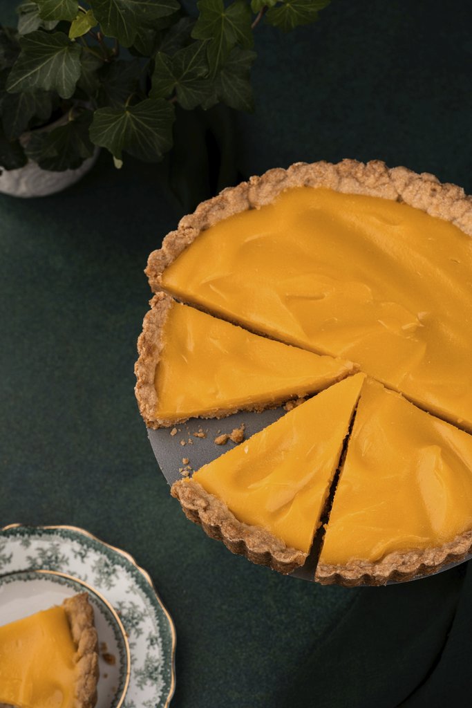 Skyler Ewing - A mouth-watering pumpkin pie with cut slices serving on a decorative plate, perfect for autumn gatherings.