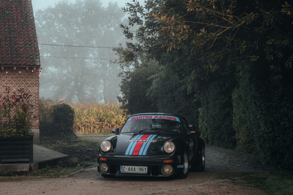 Classic 911 in Martini Colors parked on a misty rural lane, showcasing its iconic design and racing heritage.