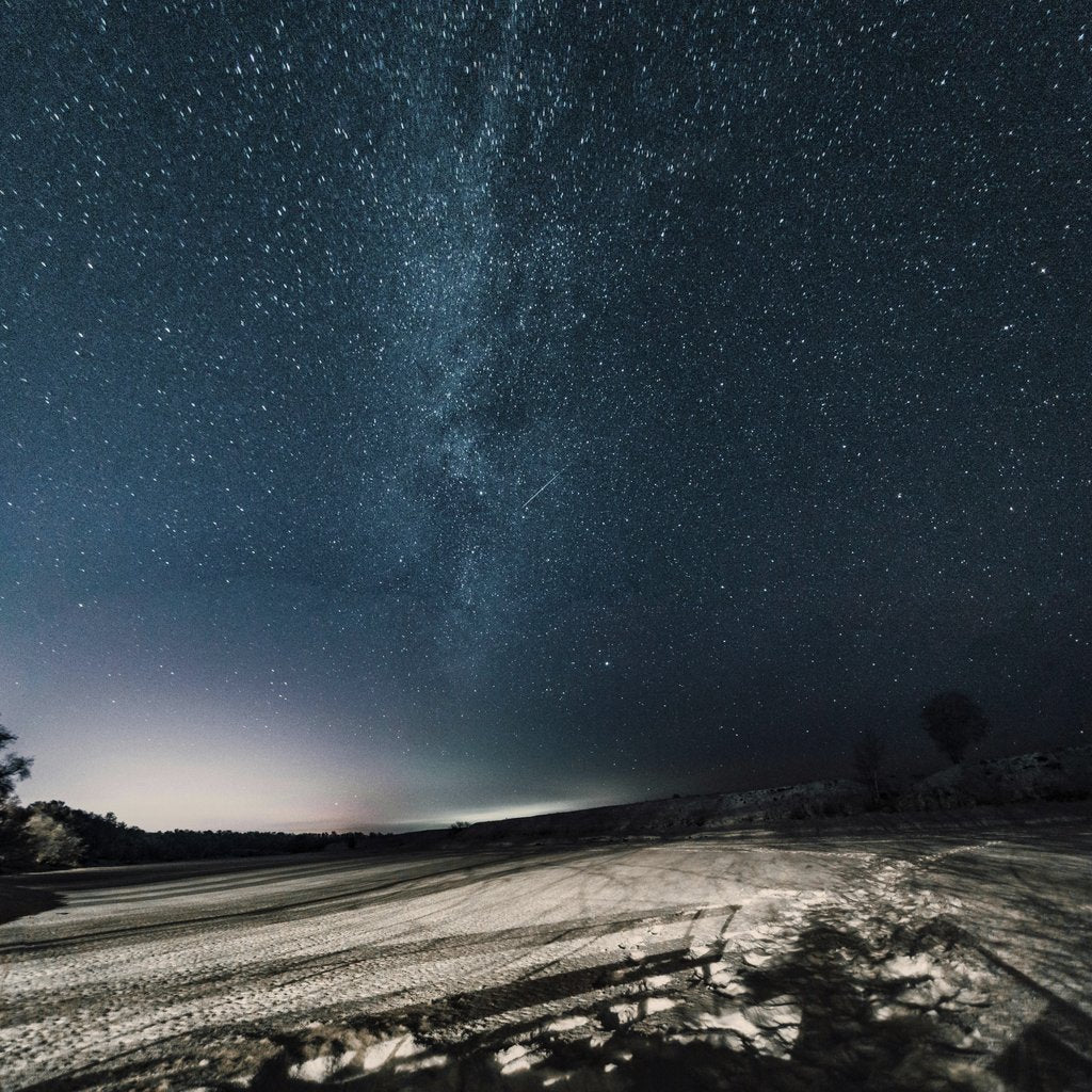Евгений Шухман - A breathtaking view of a starry night sky over a desert landscape, showcasing the Milky Way.