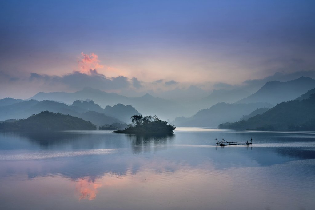 Quang Nguyen Vinh - Tranquil lake with misty mountains at sunrise in Thượng Lâm, Vietnam.