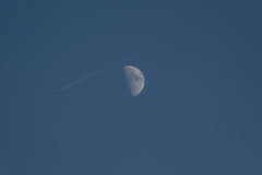 Doğan Alpaslan Demir - Half moon and airplane contrail in a clear blue sky captured in daylight.