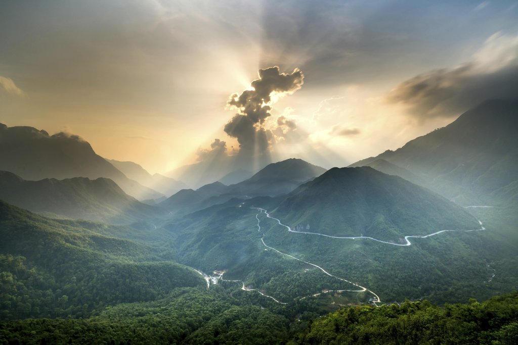 Quang Nguyen Vinh - A stunning view of a sunlit mountain landscape showcasing dramatic clouds and winding roads.