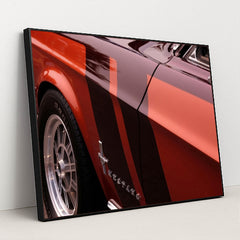 This artwork features a close-up of a classic red Ford Mustang with black and red racing stripes, in a black frame.