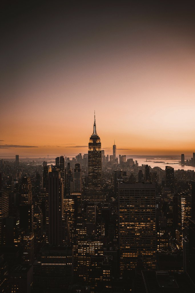 Kyle Miller - A breathtaking view of New York City's skyline at sunset, featuring iconic skyscrapers.