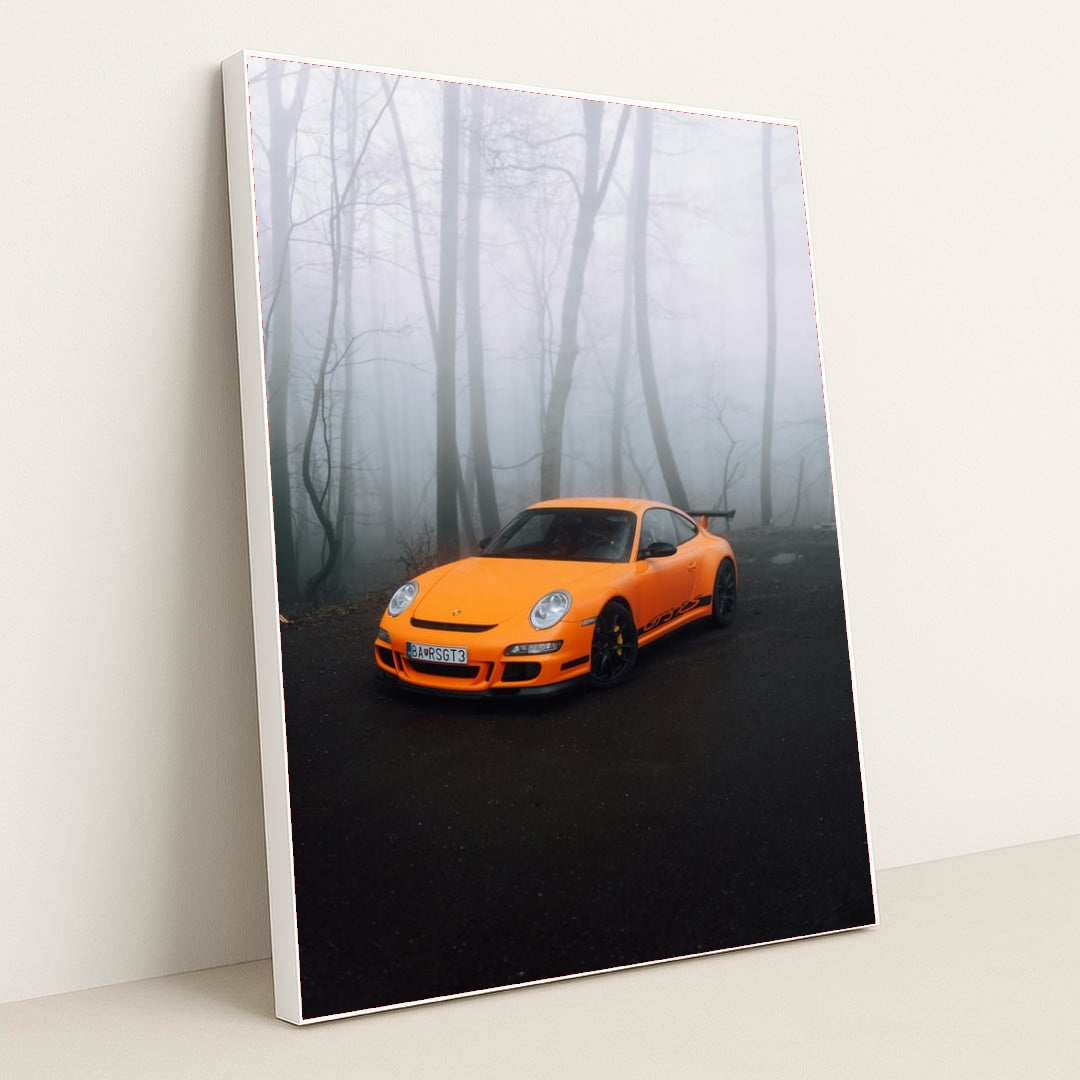 This photo shows an orange Porsche sports car parked on a misty forest road, in a white frame.