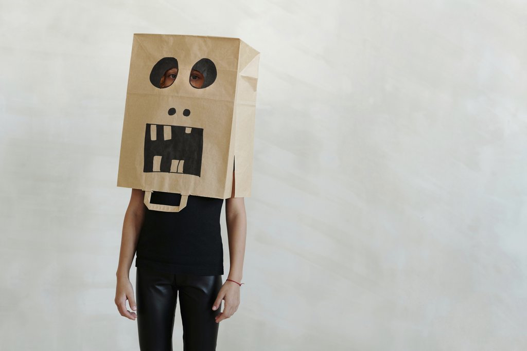 Daisy Anderson - A child wearing a handmade spooky paper bag mask, capturing a playful Halloween theme.