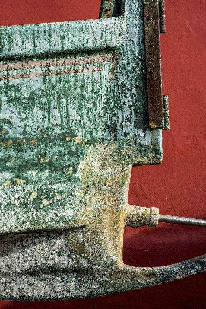 Victor Moragriega - Detailed close-up of a rusty metal object against a vibrant red background.
