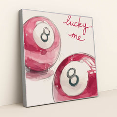 This artwork shows two pink magic eight balls with the words "lucky me" written in bright script above, in a silver frame.