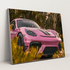 This photo shows a pink Porsche sports car with black stripes parked near tropical palm trees, in a silver frame.