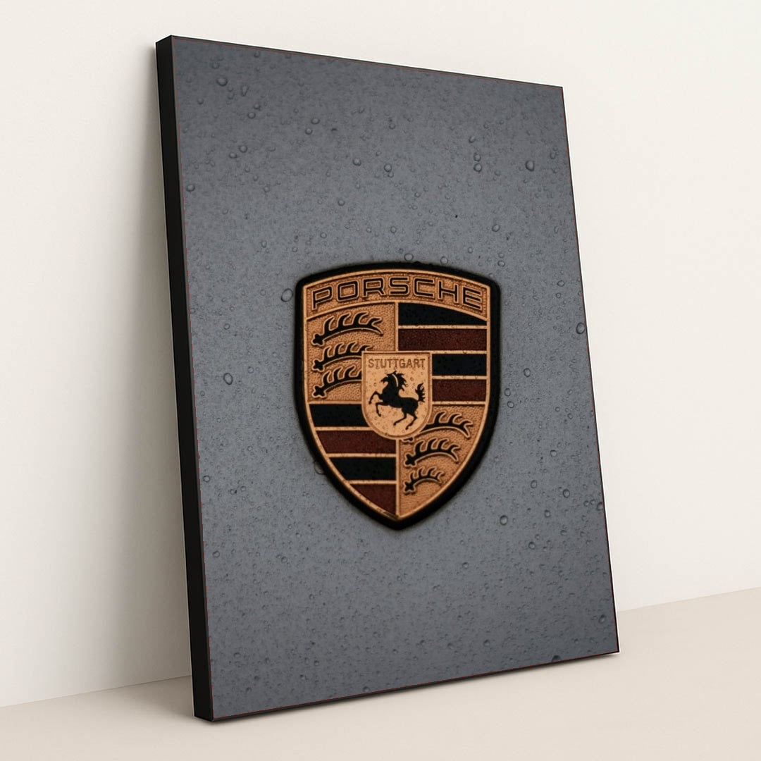 This photo features a gold Porsche emblem with raindrops on a gray car hood, in a black frame.