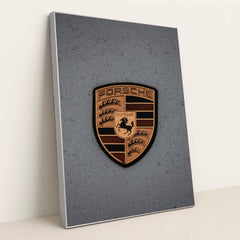 This photo features a gold Porsche emblem with raindrops on a gray car hood, in a silver frame.