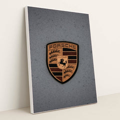 This photo features a gold Porsche emblem with raindrops on a gray car hood, in a white frame.
