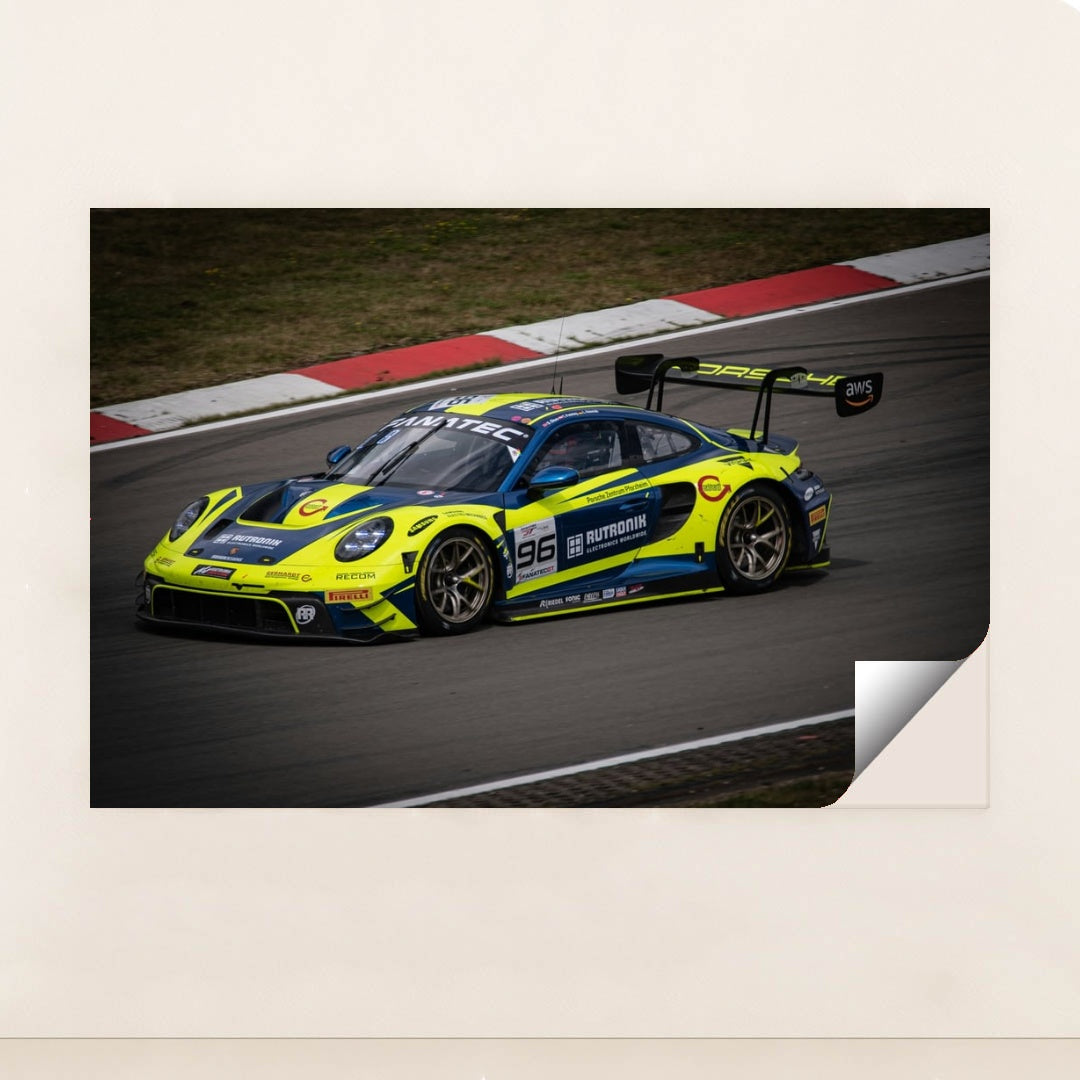 This photo shows a blue and yellow Porsche race car numbered 96 on a racetrack, unframed.