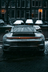 Porsche 911 Turbo S in Winter Streets, showcasing LED taillights and active rear wing on a snow-dusted street.