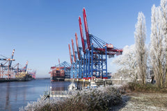 Wolfgang Weiser - Frosty winter view of Hamburg port with vibrant cargo cranes and container ships under clear skies.