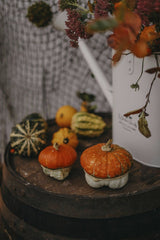 Valeria Boltneva - A rustic autumn display featuring pumpkins and gourds on a wooden barrel, perfect for fall decor.
