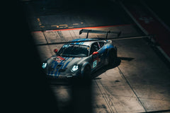 Porsche 911 GT3 Gran Turismo Racer in the pit lane, showcasing car wall art with striking silver and blue livery.