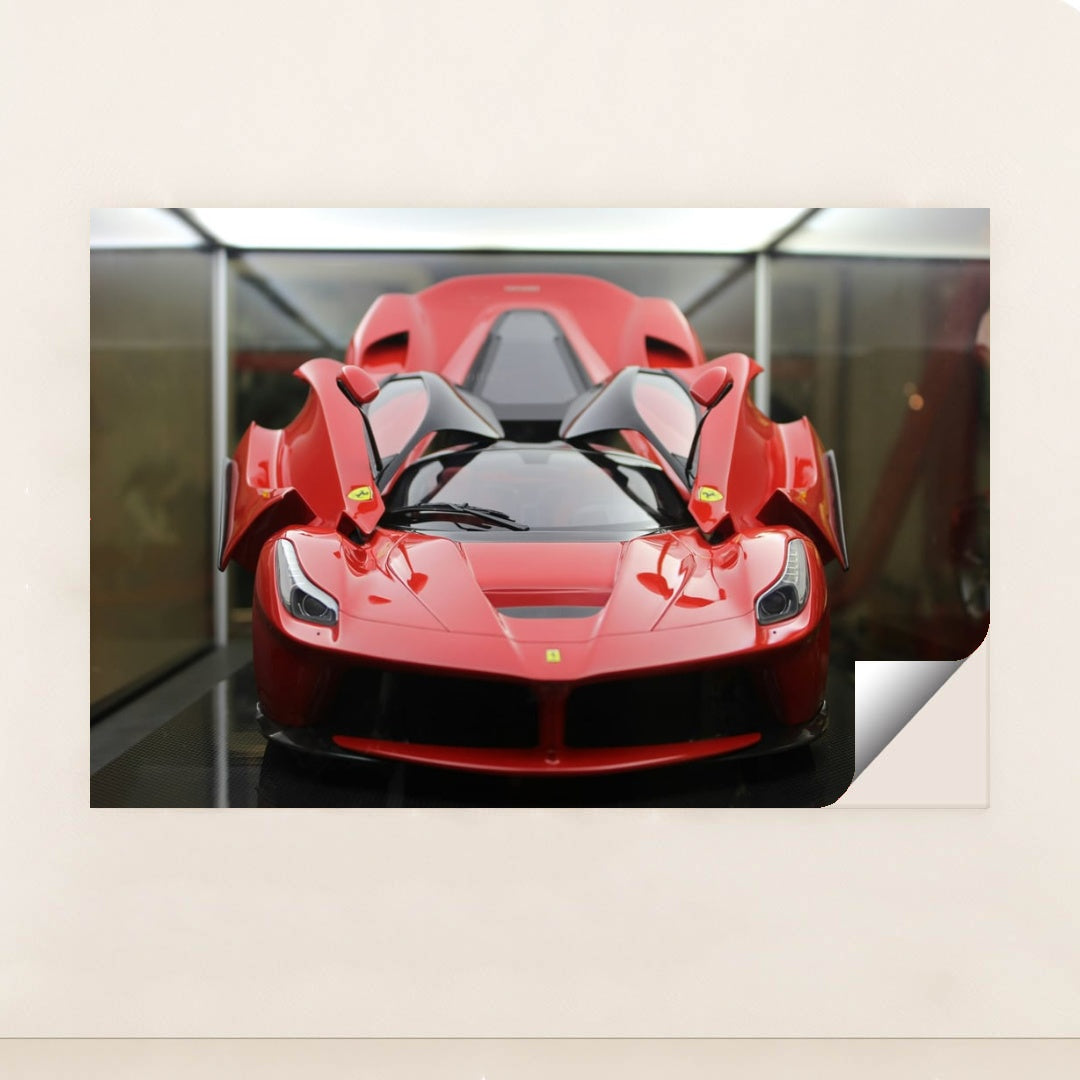 This photo shows a red Ferrari LaFerrari with scissor doors open, displayed indoors under soft lighting, minimalist unframed style.