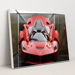 This photo shows a red Ferrari LaFerrari with scissor doors open, displayed indoors under soft lighting, in a white frame.