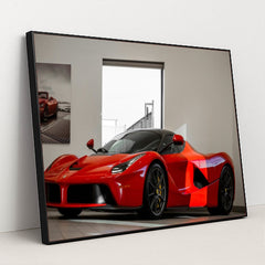 This photo shows a red Ferrari LaFerrari coupe displayed in a bright, modern showroom, in a black frame.