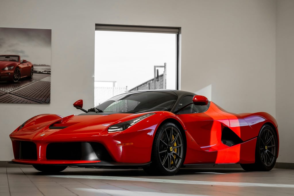 Ferrari LaFerrari on Display in sleek showroom with polished red exterior and aerodynamic features.