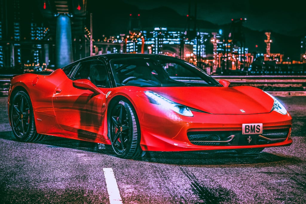 Ferrari 458 Italia Amid City Lights, showcasing its glossy red finish and sleek design under urban lights.