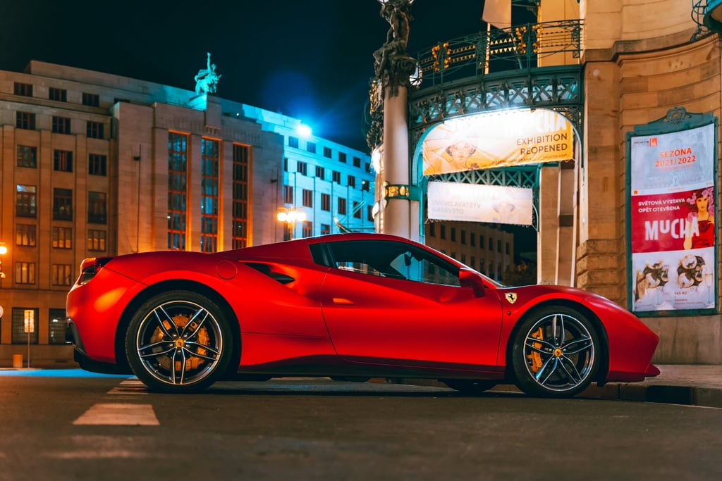 Ferrari 488 GTB Glowing Red parked at night in a vibrant urban square, showcasing car wall art with sleek design.