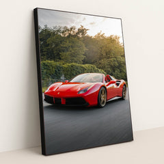 This photo shows a red Ferrari 488 Spider driving on a road with trees in the background, in a black frame.