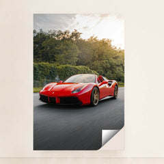 This photo shows a red Ferrari 488 Spider driving on a road with trees in the background, unframed style.