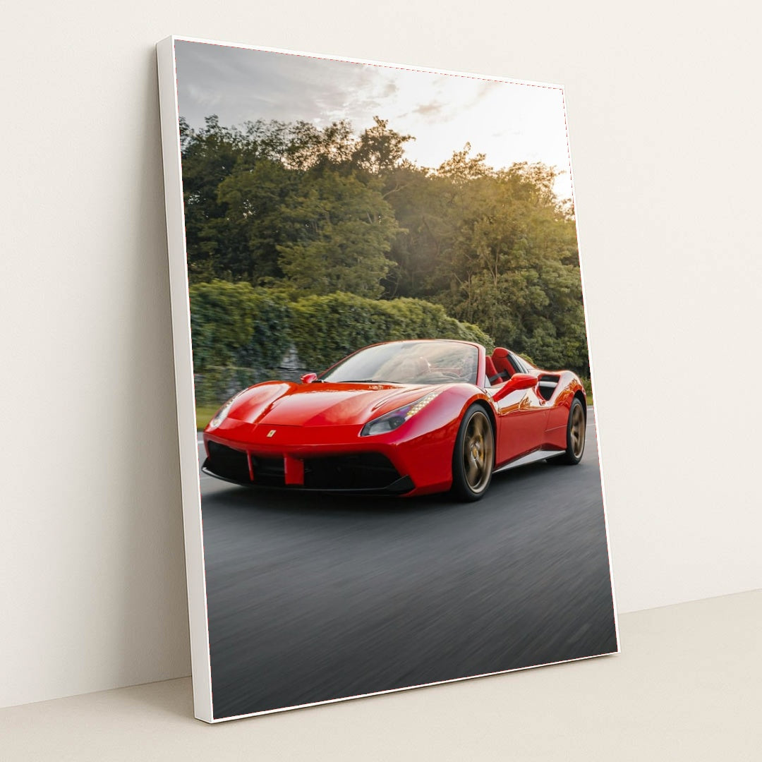 This photo shows a red Ferrari 488 Spider driving on a road with trees in the background, in a white frame.