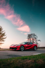 Ferrari 812 Superfast at Sunset, showcasing its Rosso Corsa body under a vibrant sky, perfect for car wall art.