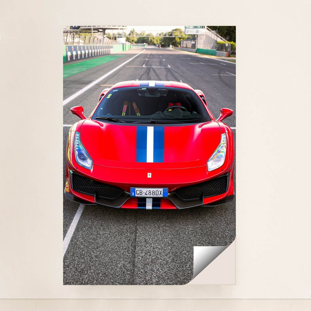 This photo shows the front view of a red Ferrari 488 Pista with a blue and white racing stripe parked on a racetrack, unframed style.