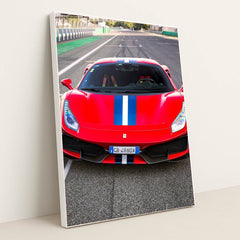 This photo shows the front view of a red Ferrari 488 Pista with a blue and white racing stripe parked on a racetrack, in a white frame.