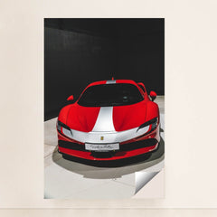 This photo shows a red Ferrari sports car with a white racing stripe parked indoors under direct lighting, minimalist unframed style.