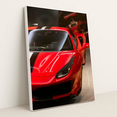 This photo shows the front left side of a red Ferrari with a black and white racing stripe, parked indoors, in a silver frame.