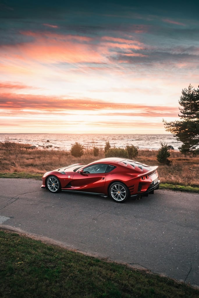 Ferrari 812 Superfast on Coastal Road, parked by the sea with a sunset backdrop, ideal for car wall art.