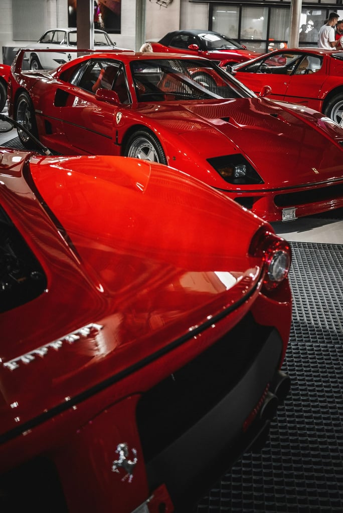 A Ferrari Collection showcasing iconic red Ferrari models, including the F40 and Enzo, framed by dramatic lighting.