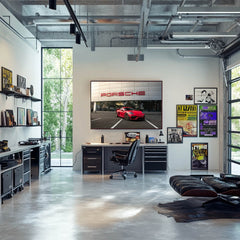 Stylish home office with a Red Cayman GT4 at Porsche Dealership art on the wall, featuring modern decor and large windows.