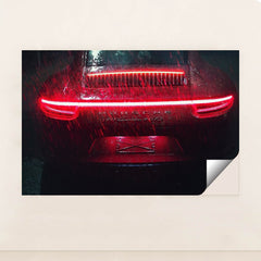 This photo shows the rear of a Porsche 911 Carrera 4 GTS during heavy rain at night with bright red taillights, minimalist unframed style.
