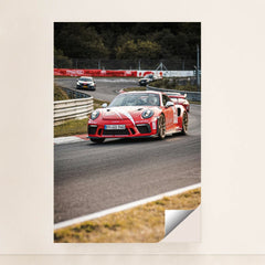 This photo shows a red Porsche GT3 RS race car with white stripes driving on a track during a motorsport event, minimalist unframed style.