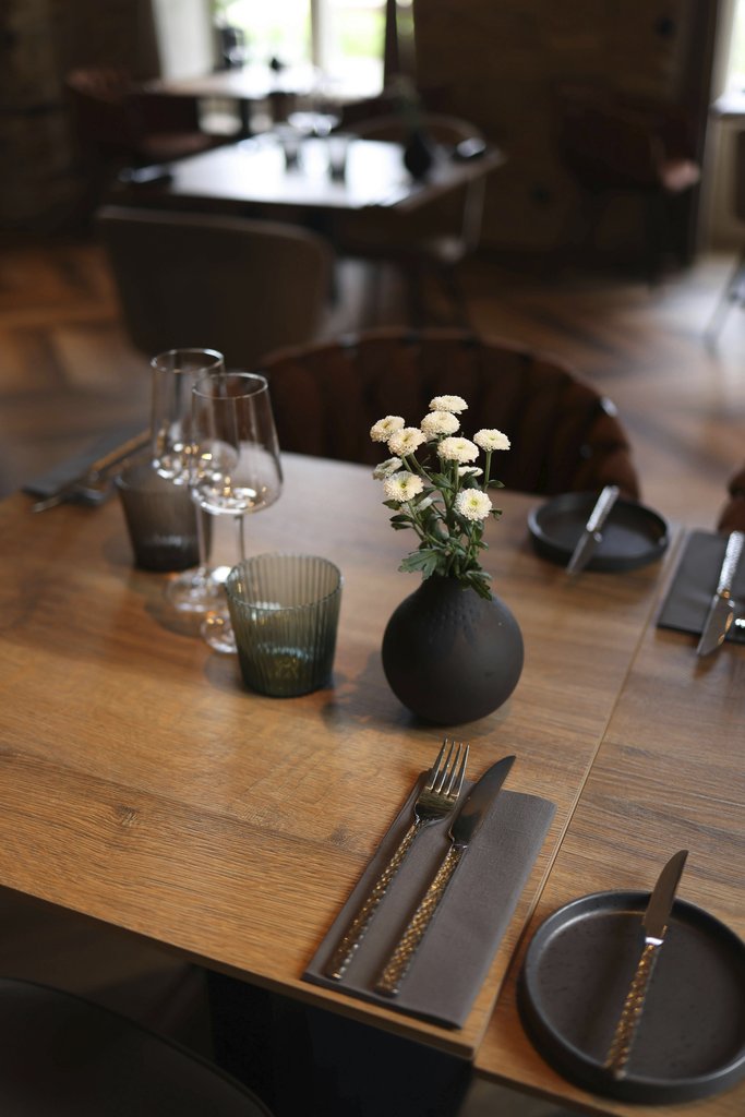 Valeria Boltneva - A sophisticated restaurant table setting featuring elegant cutlery and floral decoration, perfect for fine dining.