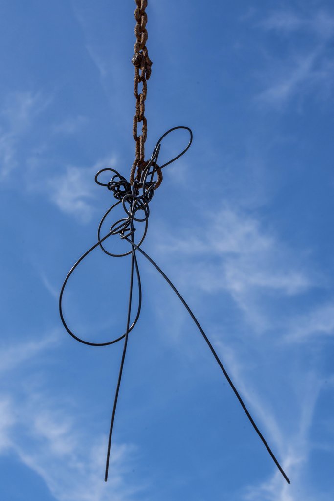 Victor Moragriega - Steel wire sculpture hanging against a bright blue sky, showcasing modern artistic expression.
