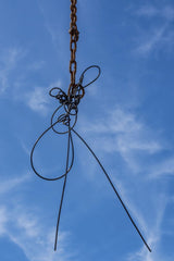 Victor Moragriega - Steel wire sculpture hanging against a bright blue sky, showcasing modern artistic expression.