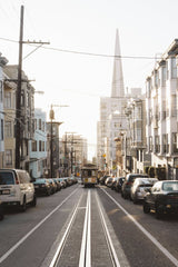 Alex Azabache - A scenic street view in San Francisco featuring the iconic Transamerica Pyramid and a tram.
