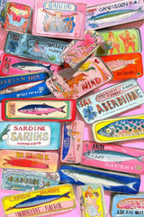 This artwork shows a colorful collection of decorative sardine cans with vintage-style labels, layered on a pink background, unframed.
