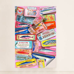 This artwork shows a colorful collection of decorative sardine cans with vintage-style labels, layered on a pink background, minimalist unframed style.