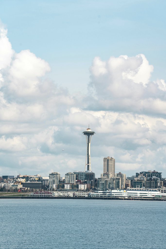 Jared Lung - A captivating view of Seattle's skyline featuring the iconic Space Needle under a bright cloudy sky.
