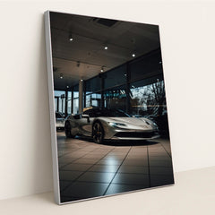 This photo shows a silver Ferrari SF90 Stradale parked inside a showroom with large windows, in a silver frame.