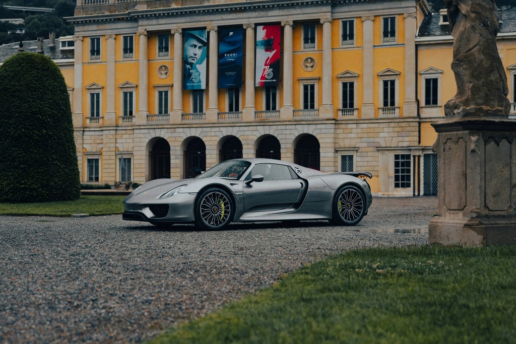 Porsche 918 Spyder at European Estate parked on gravel drive, showcasing its sleek design against grand architecture.