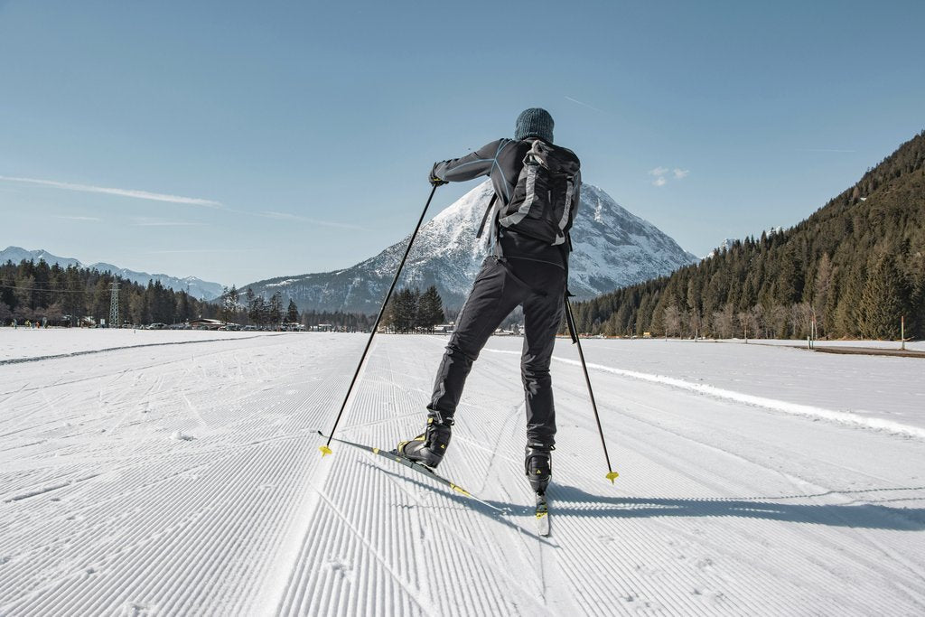 Tobi &Chris - Skier enjoying cross-country skiing in beautiful Tirol, Austria, framed by snowy mountains.